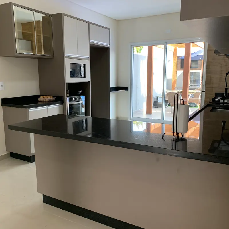 Ilha em pedra escura com cooktop e cuba